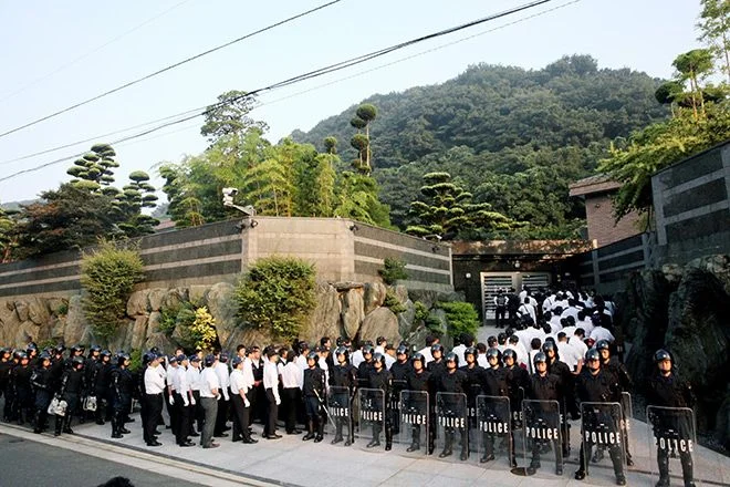 Investigators enter the home of yakuza don Satoru Nomura in Kita Kyushu's Kokura-Kita Ward on Sept. 11, 2014.