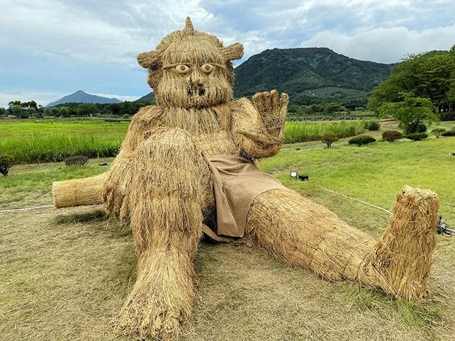 A straw sculpture of Fujin (God of wind) appears to greet people in Uwasekigata Koen Park