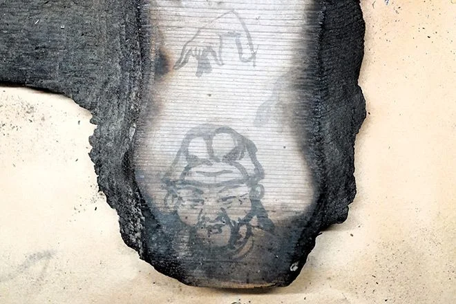 Graffiti of a man's face and a hand were found on a charred ceiling board from the Kondo main hall of Horyuji temple