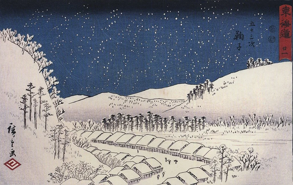 Snow falling on a town.